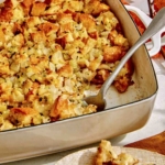Stuffing in a baking dish with a spoon in it.
