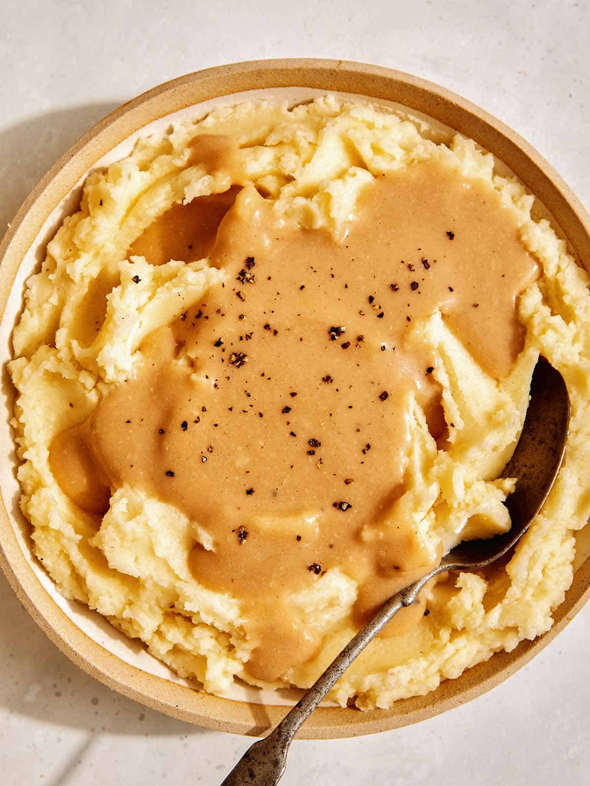 Mashed potatoes with gravy poured over them. 