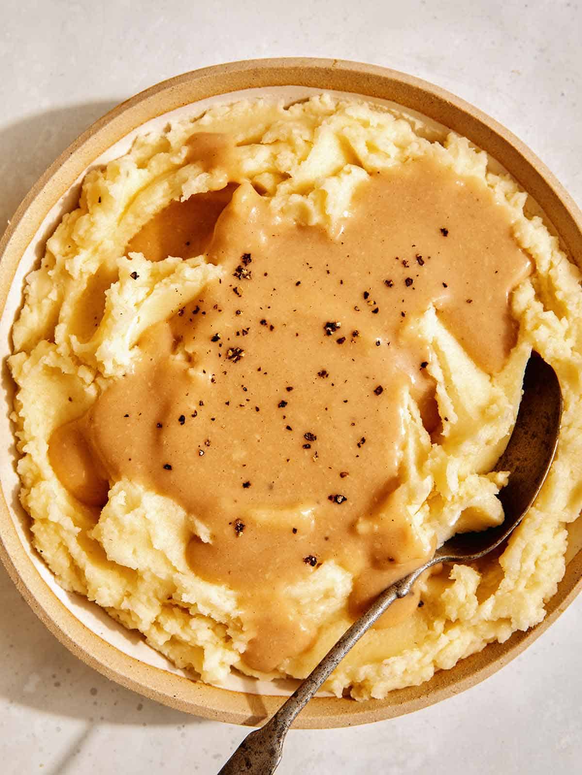 Mashed potatoes with gravy poured over them.