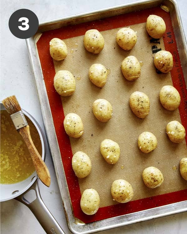 Basting hasselback potatoes.