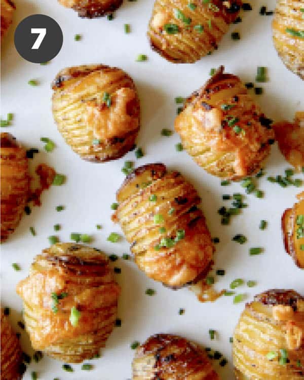 Hasselback potatoes with cheese on top and sprinkled with chives.