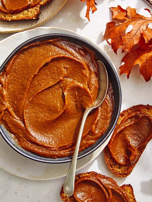 Pumpkin butter in a bowl with toast next to it.