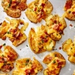 Crispy smashed potatoes on a baking sheet.