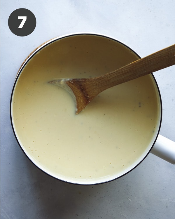 Cooking a cheese sauce in a skillet for stovetop mac and cheese. 