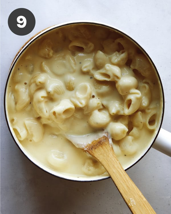 Stovetop mac and cheese in a skillet with wooden spoon.
