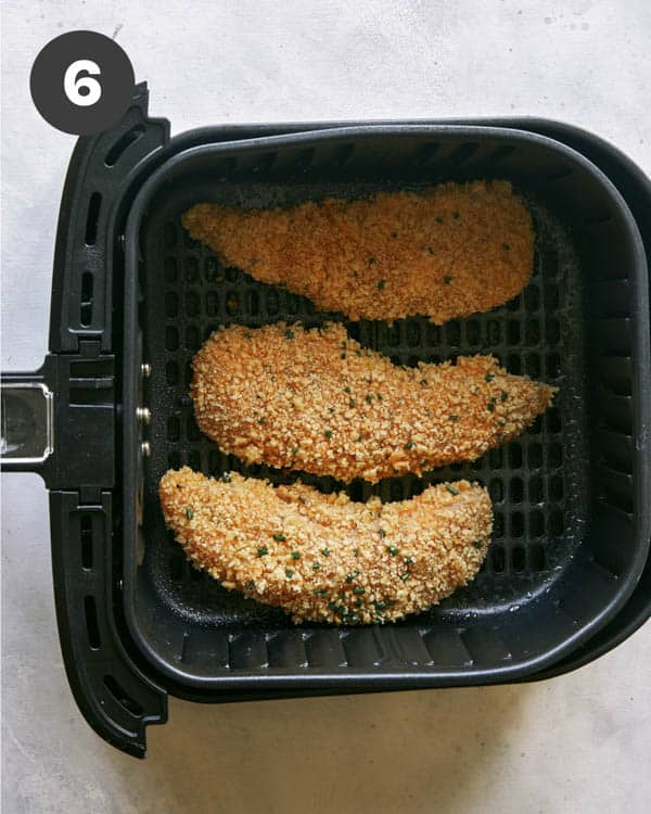 Air fryer chicken tenders in the basket ready to be cooked. 