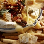 Baked brie on a platter with crackers.