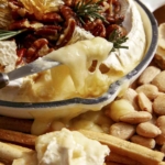 Baked brie on a platter with crackers.