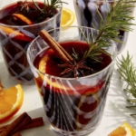 Mulled wine in glasses with garnish around them.