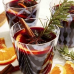 Mulled wine in glasses with garnish around them.