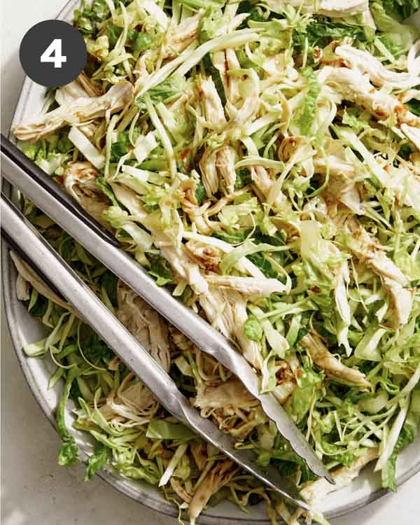 Sesame ginger chicken salad tossed together on a platter. 