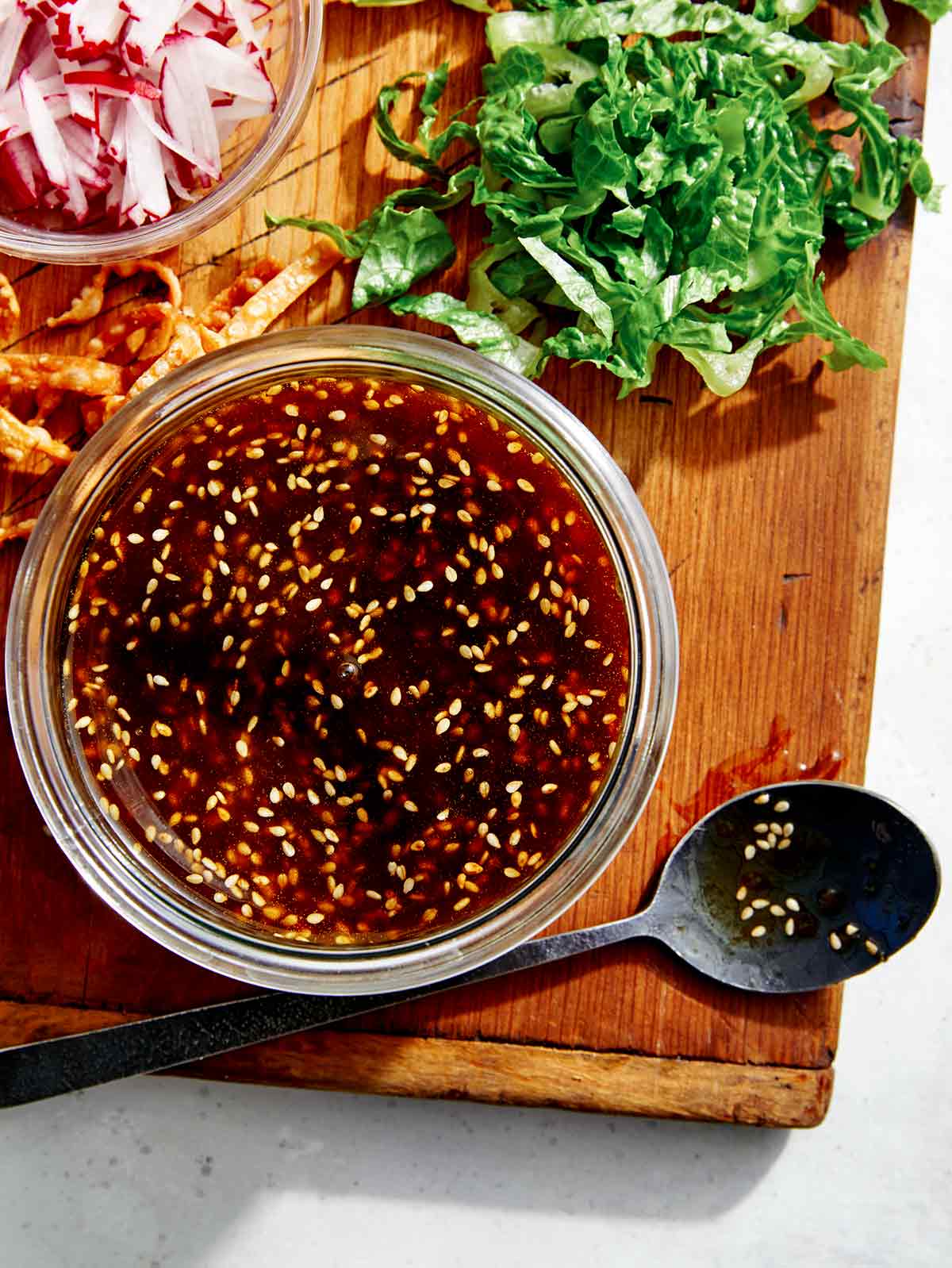 Sesame ginger salad dressing with salad ingredients on the side. 