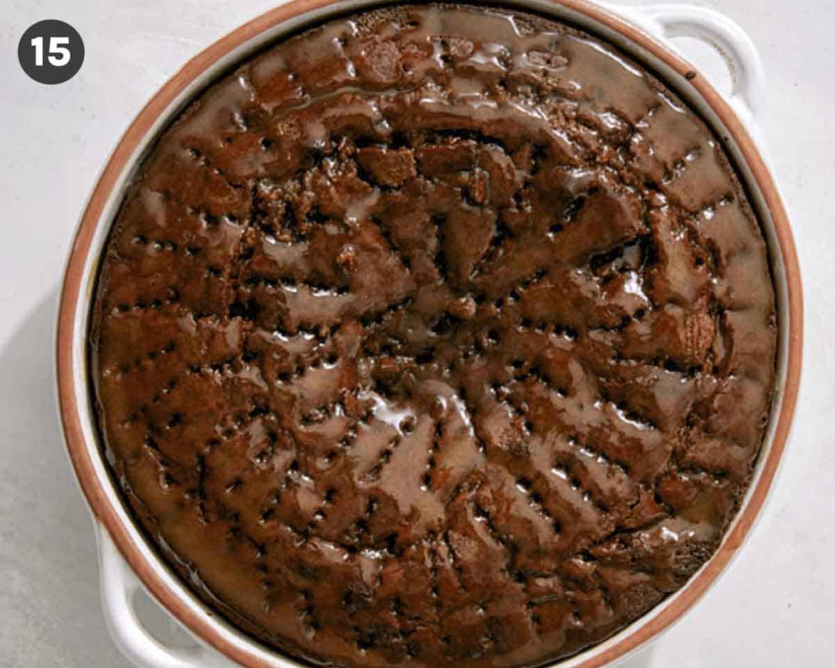 Sticky toffee pudding in a baking dish with sauce over it.