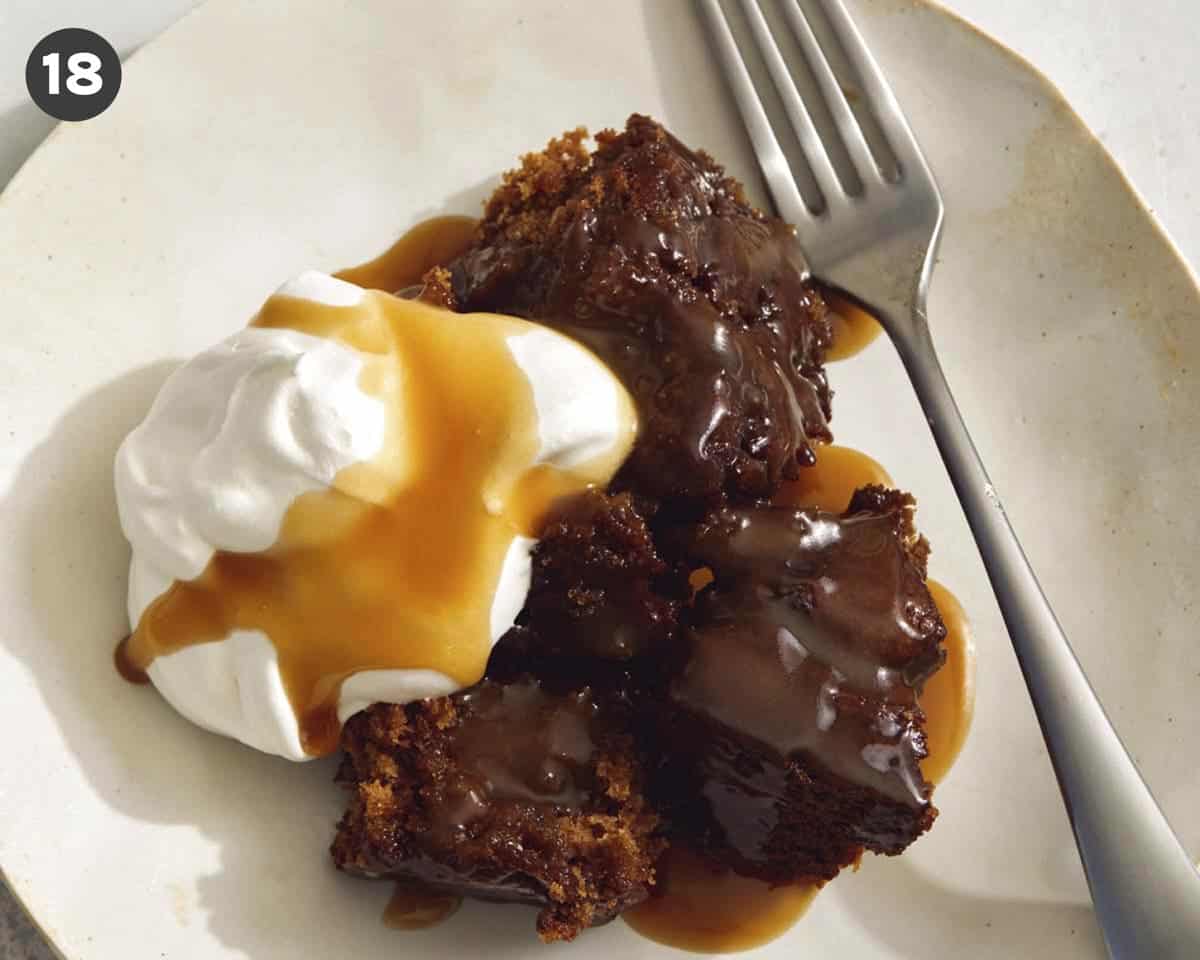 Sticky Toffee pudding on a plate with whipped cream and a fork.