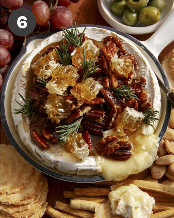Baked brie in a skillet served with crackers. 