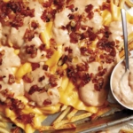 Animal style fries on a baking sheet.