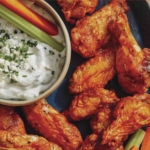 Air fryer buffalo wings on a platter being served.