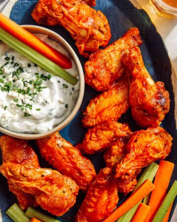Air fryer buffalo wings on a platter being served.