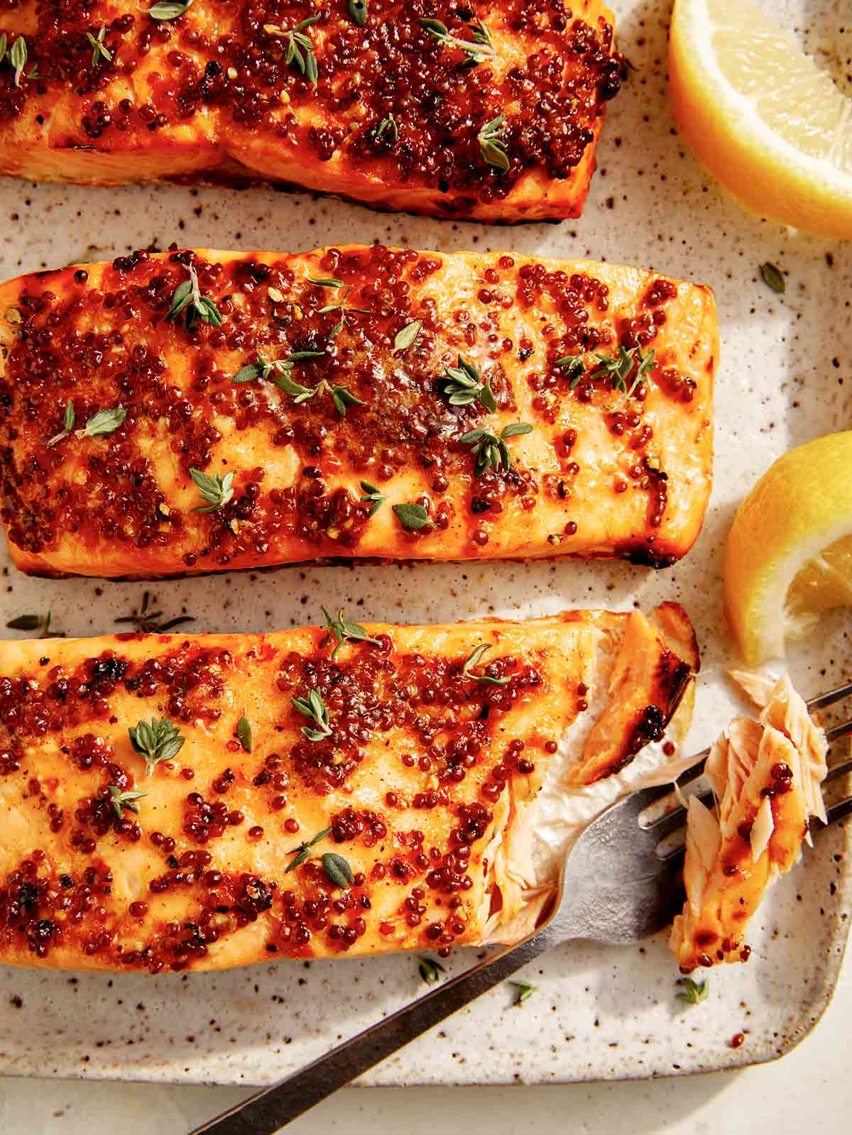 Air fryer salmon on a plate with a fork taking a bite out. 