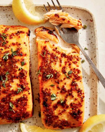 Air fryer salmon on a platter with lemon.