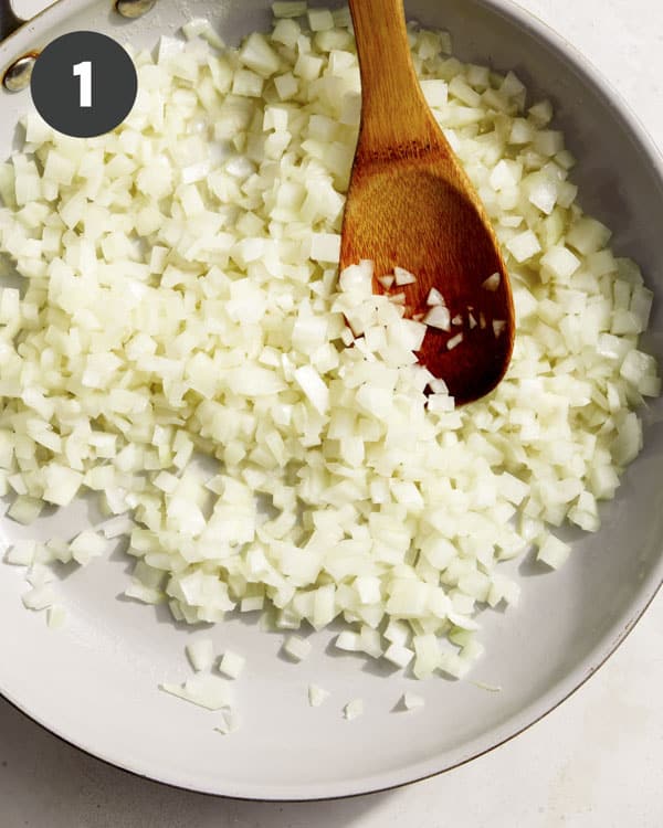 Onions cooking in a skillet for animal style fries.