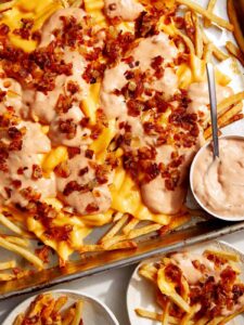 Animal style fries on a baking sheet.