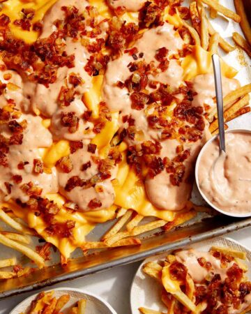 Animal style fries on a baking sheet.