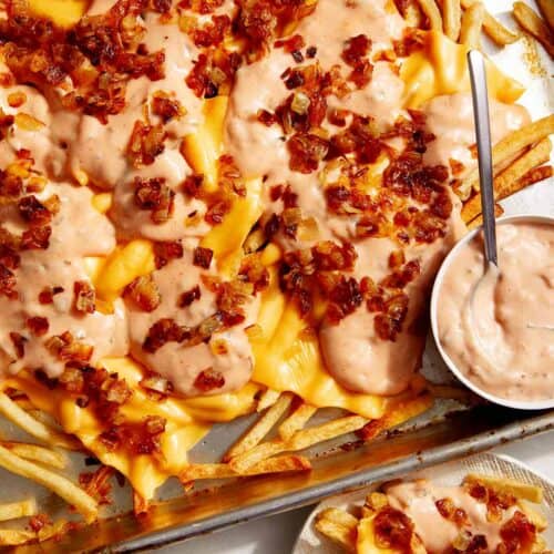 Animal style fries on a baking sheet.