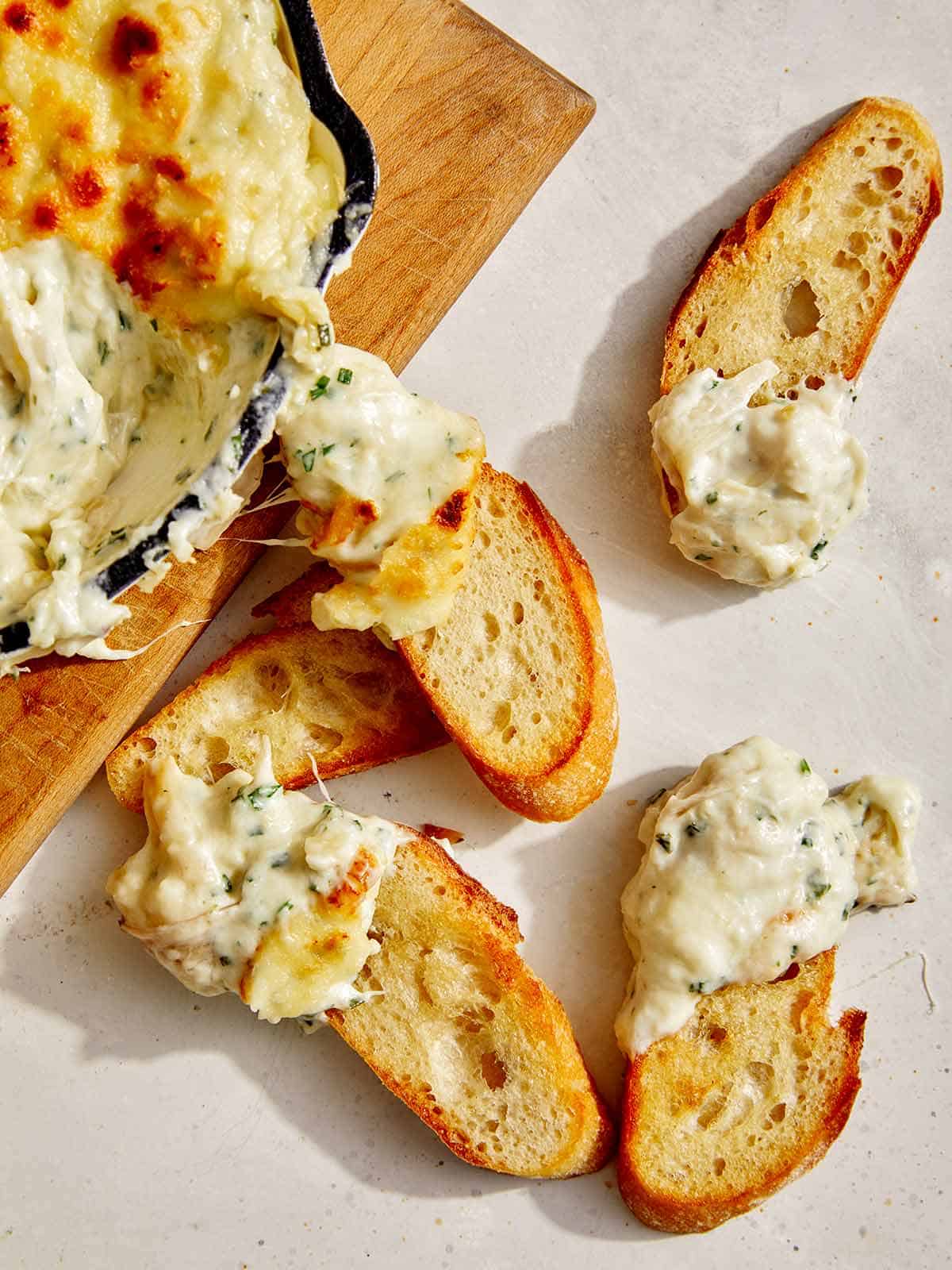 Baked garlic bread dip on crostini for an appetizer.