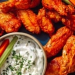 Close up on air fryer buffalo wings with a dipping sauce.