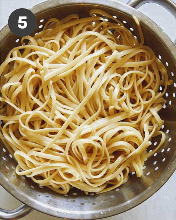 Linguine cooked and in a colander.