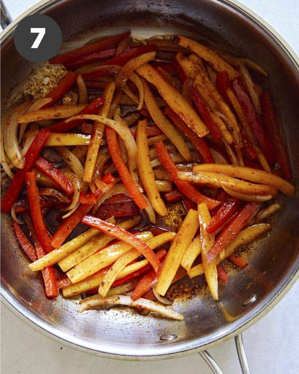 Bell peppers cooking in a skillet to make Cajun Shrimp.