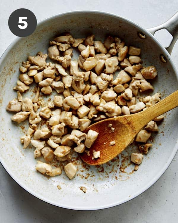 Chicken in a skillet cooking to make cashew chicken.