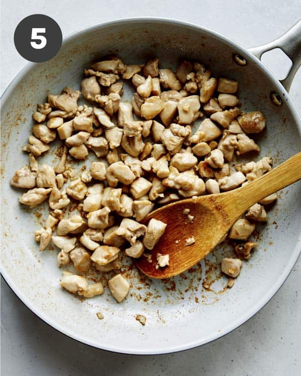 Chicken in a skillet cooking to make cashew chicken. 