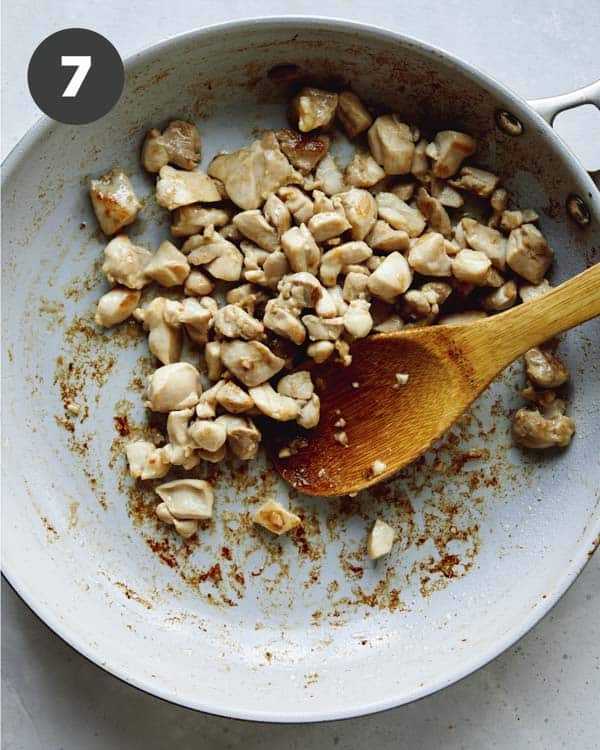 Chicken cooking in a skillet for cashew chicken.