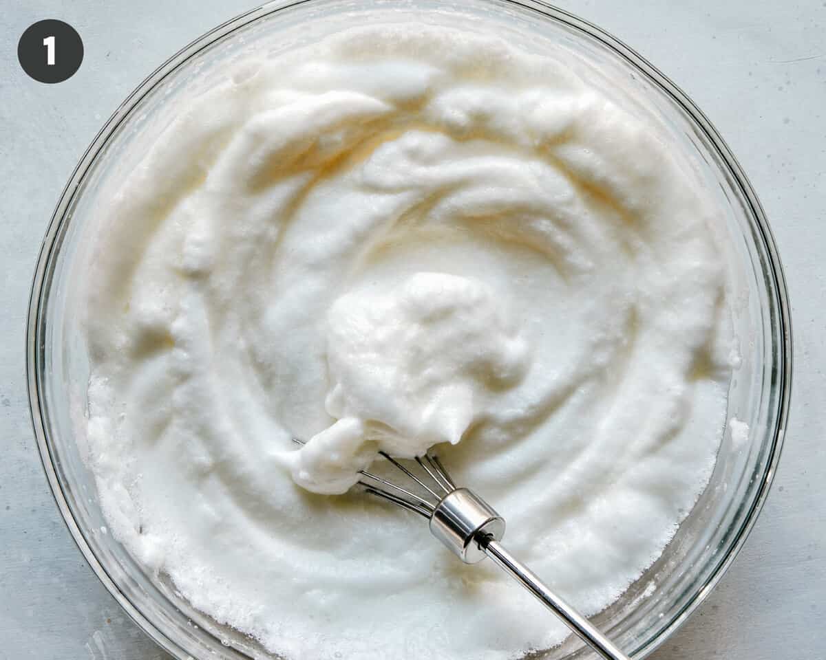 Egg white beaten in a bowl until soft peaks form.