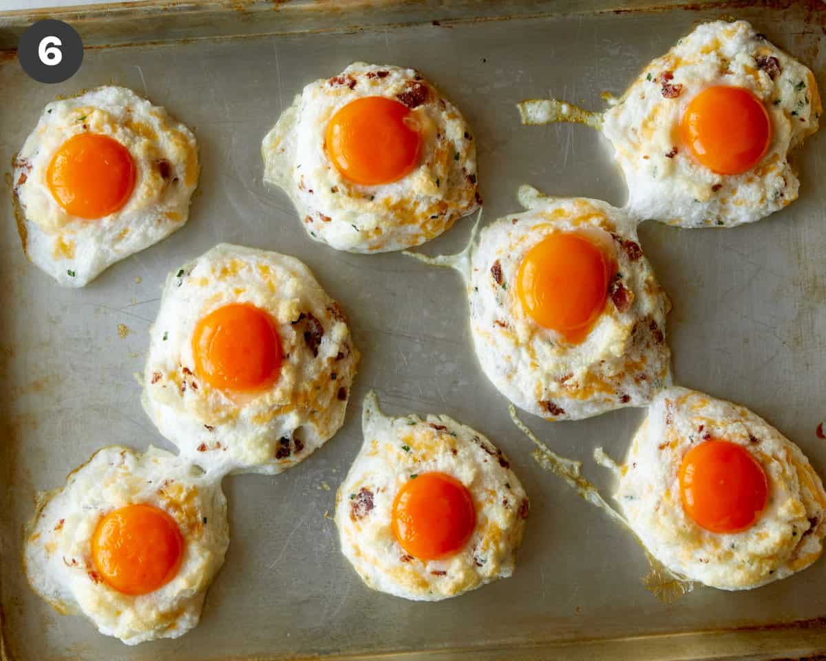 Egg clouds with egg yolks on a baking sheet.