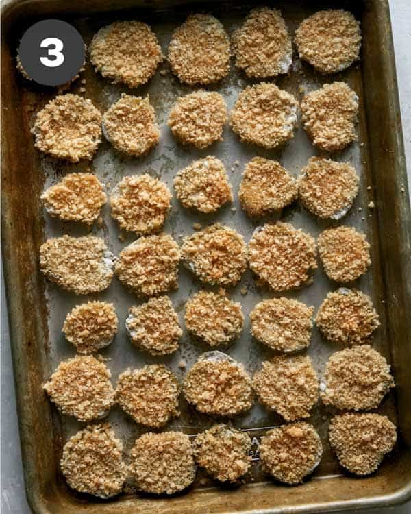 Pickle chips on a baking sheet pre fried. 