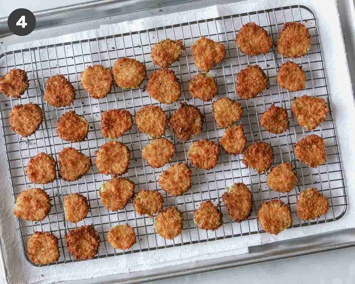 Fried pickle chips on a baking sheet. 