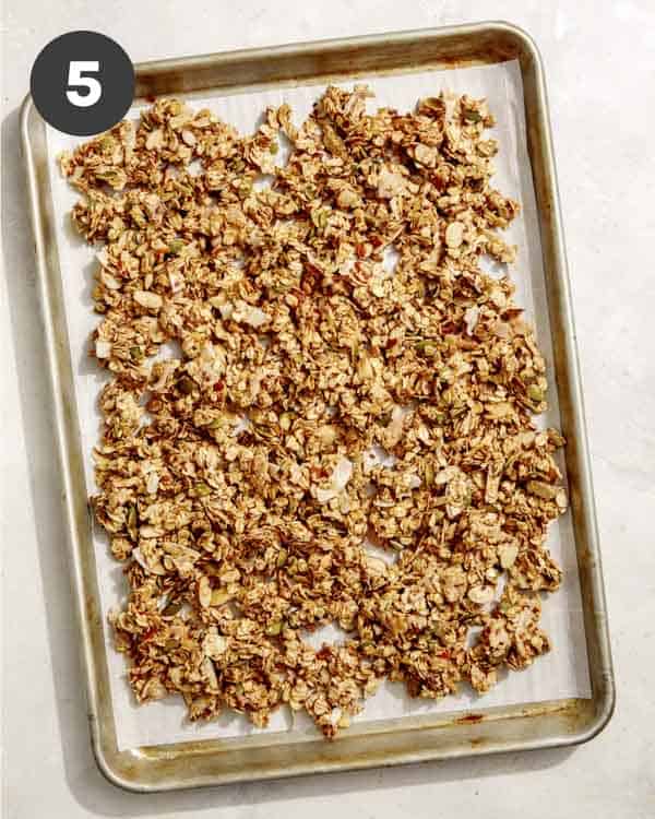 Homemade granola spread onto a baking sheet. 