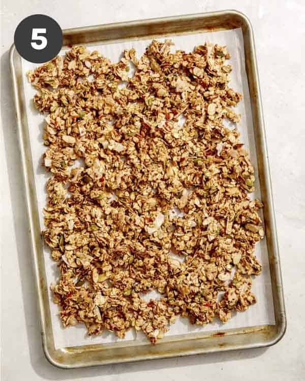 Homemade granola spread onto a baking sheet.