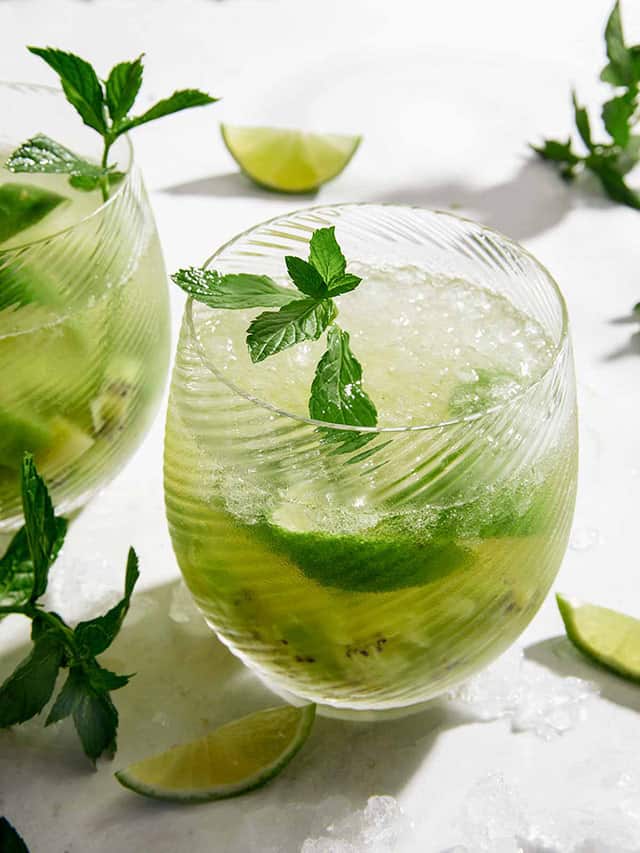 kiwi cocktail served on a glass cup with mint leaves