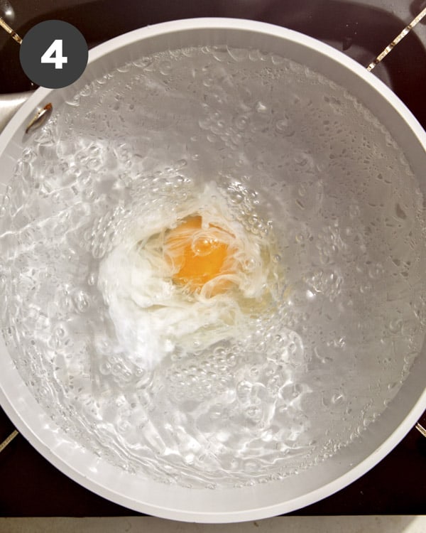 An egg being poached in a pot of water. 