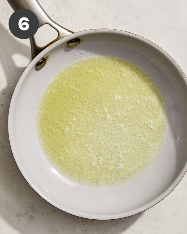 Butter melted in a small skillet to make turkish eggs.