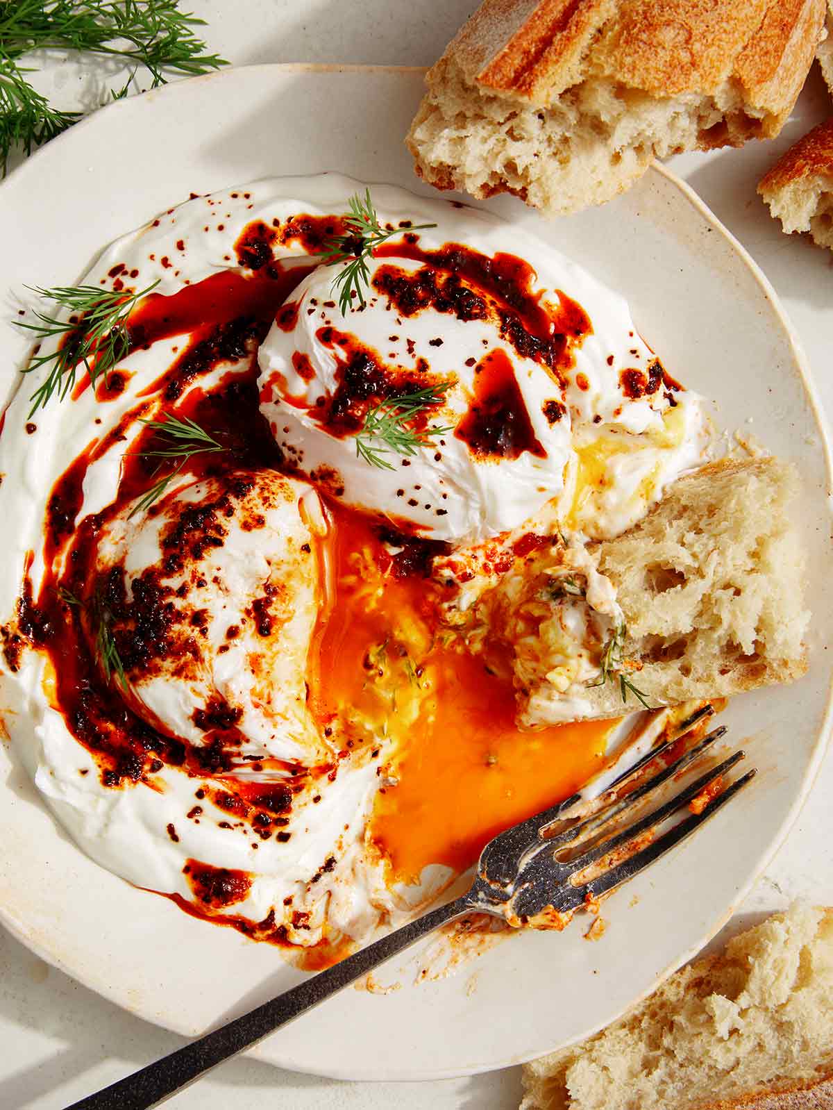 Turkish eggs (cilbir) recipe with a piece of bread in it. 
