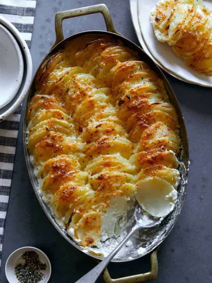 sliced potatoes on a baking dish with a spoon