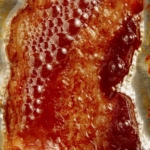 Bacon freshly cooked with bacon grease.