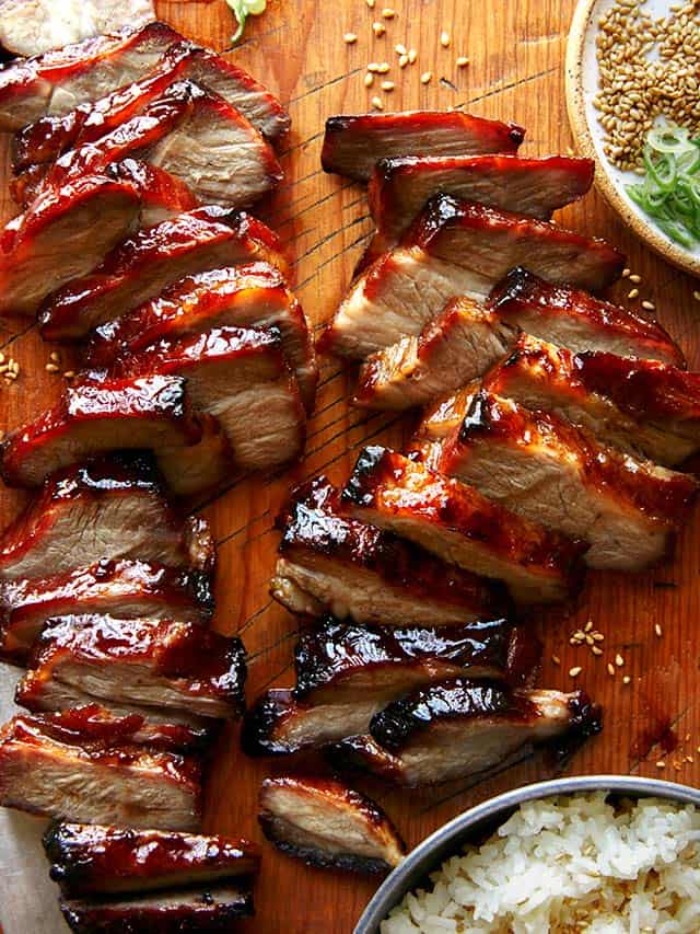 cha siu pork sliced on a wood cutting board surface