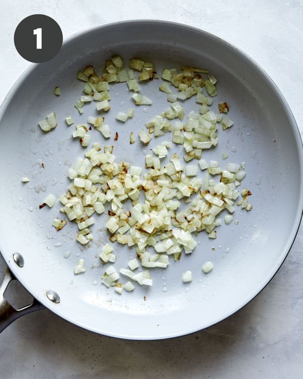 Onions and garlic cooking in a skillet.