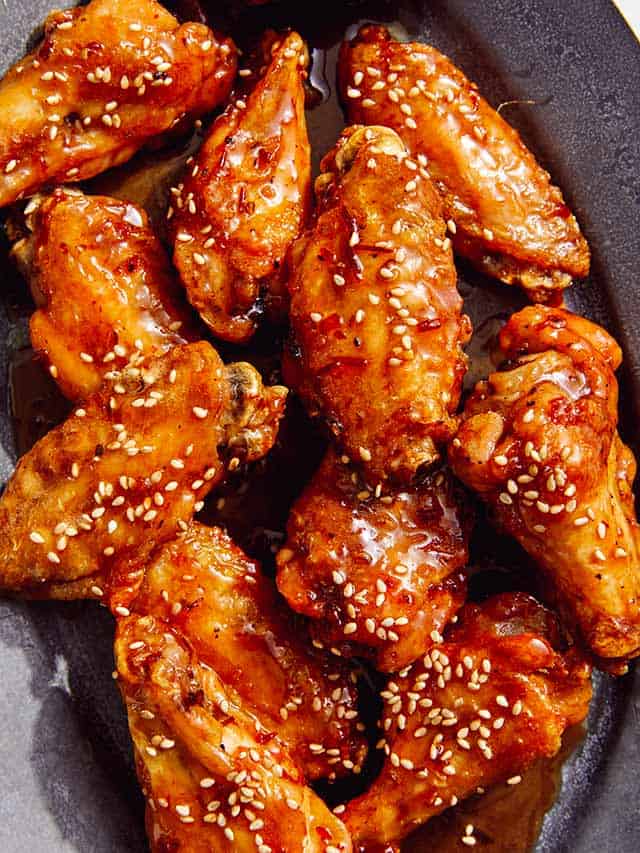 chicken wings covered with sauce and sesame seeds in a plate